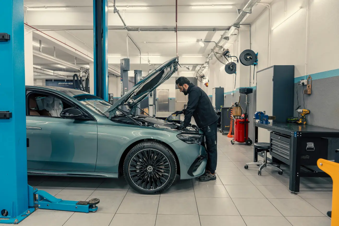 Mechanic Working on Luxury Car in Modern Garage